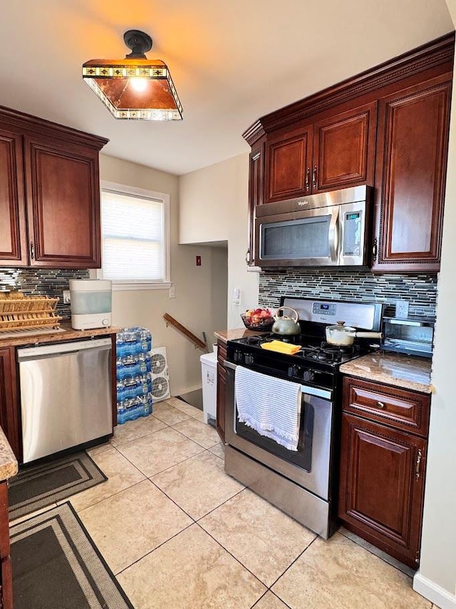 kitchen featuring appliances with stainless steel finishes, light tile patterned flooring, and tasteful backsplash