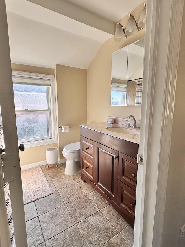 bathroom with vaulted ceiling, vanity, toilet, and baseboards