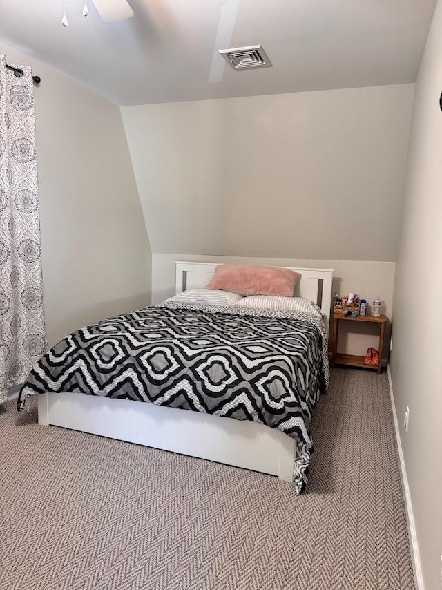 carpeted bedroom featuring baseboards, visible vents, vaulted ceiling, and a ceiling fan