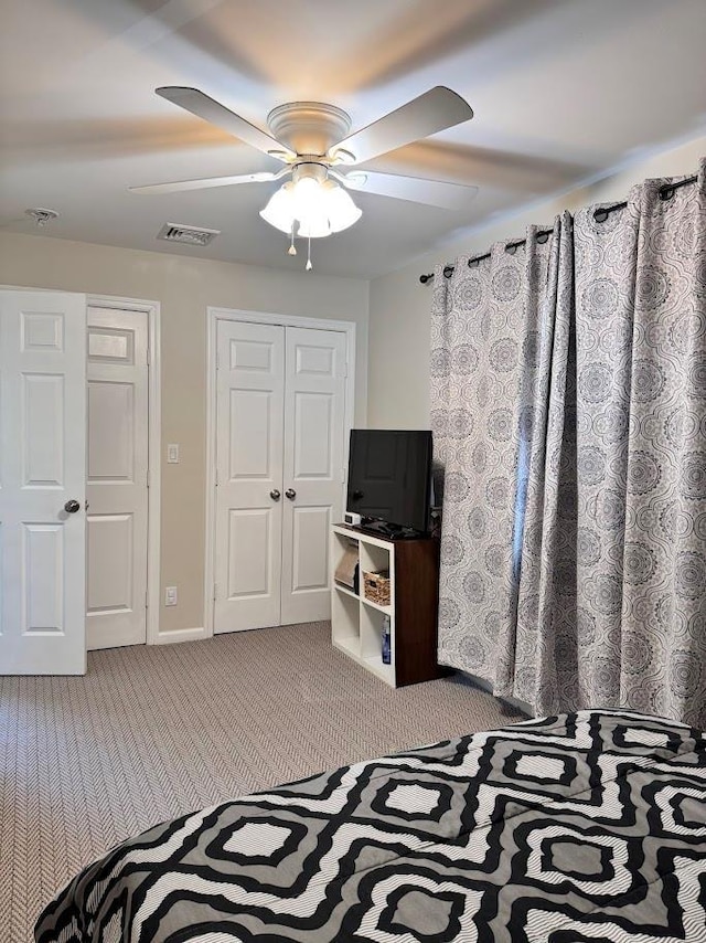 bedroom featuring visible vents, baseboards, a ceiling fan, a closet, and carpet