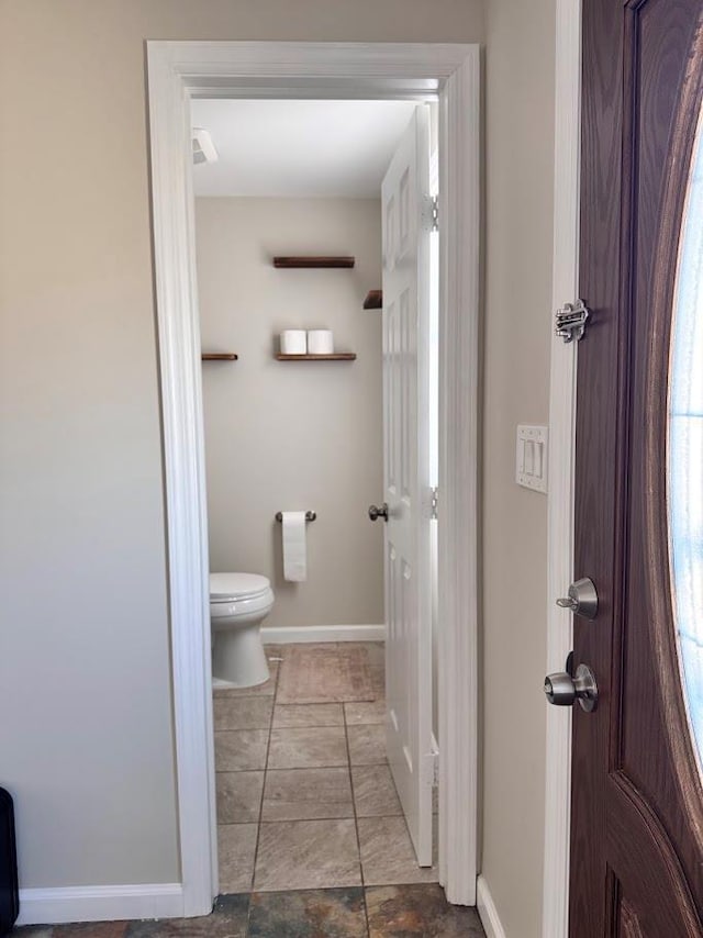 bathroom featuring toilet and baseboards