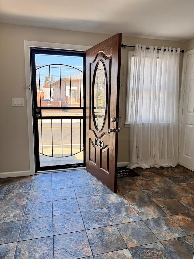 entryway with stone finish flooring and baseboards