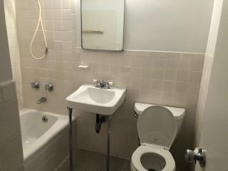 bathroom featuring shower / washtub combination, a sink, tile walls, and toilet