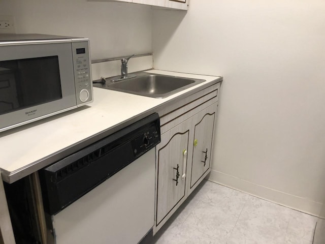 kitchen featuring baseboards, marble finish floor, white dishwasher, light countertops, and a sink