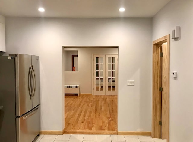 kitchen with french doors, recessed lighting, radiator, light wood-style flooring, and freestanding refrigerator