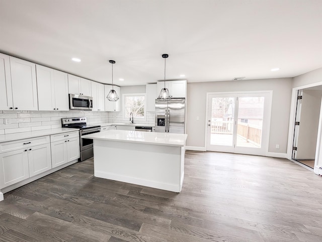 kitchen with appliances with stainless steel finishes, plenty of natural light, a sink, and backsplash