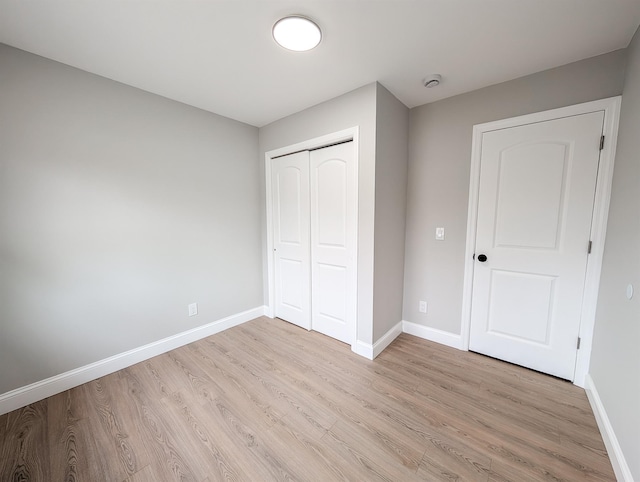 unfurnished bedroom with light wood-style flooring and baseboards