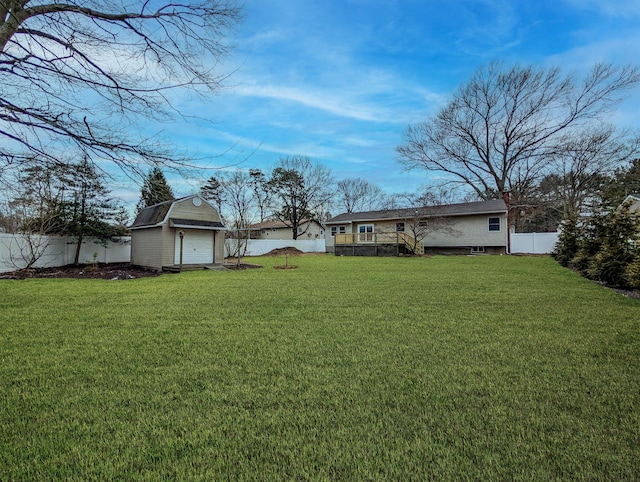 view of yard featuring a fenced backyard, a detached garage, a shed, and an outdoor structure