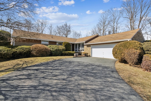 ranch-style home featuring aphalt driveway and a garage