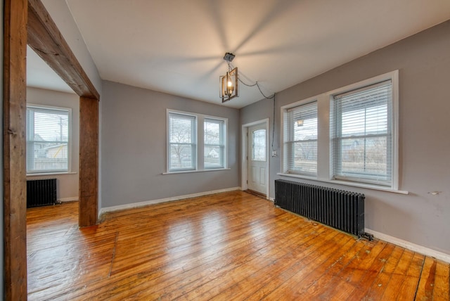 spare room with radiator, baseboards, and hardwood / wood-style floors