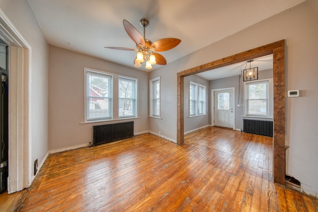 interior space featuring radiator heating unit, hardwood / wood-style flooring, and baseboards