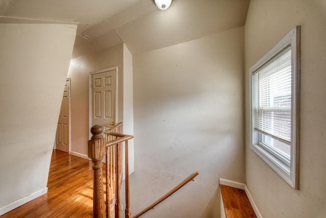 interior space with vaulted ceiling, baseboards, and wood finished floors