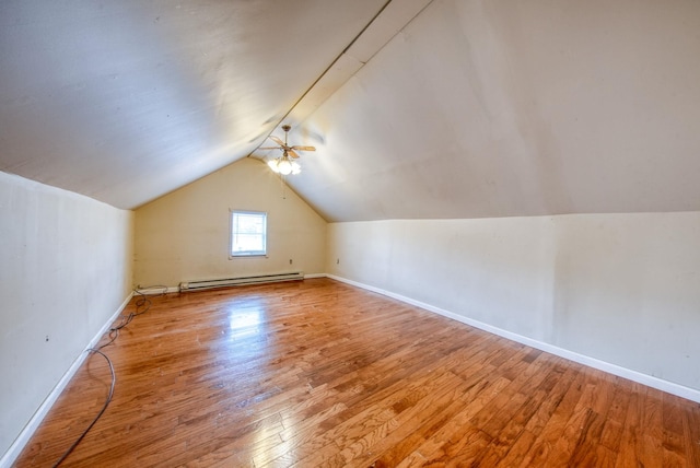 bonus room with vaulted ceiling, baseboard heating, wood finished floors, and baseboards