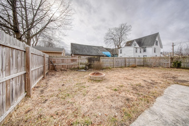 view of yard featuring a fire pit and a fenced backyard