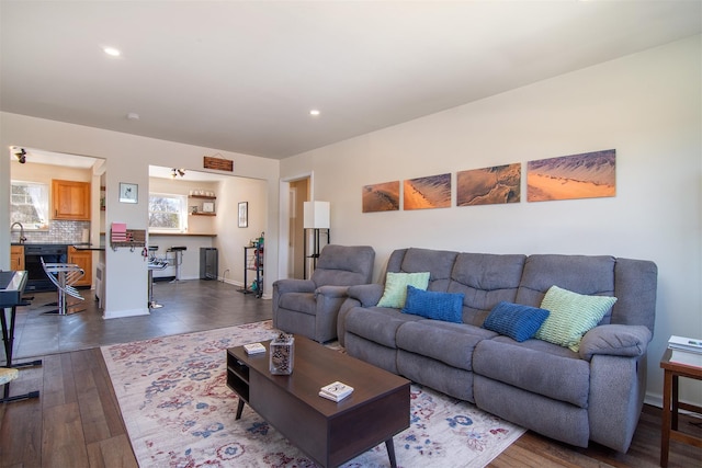 living room featuring dark wood finished floors, recessed lighting, and baseboards