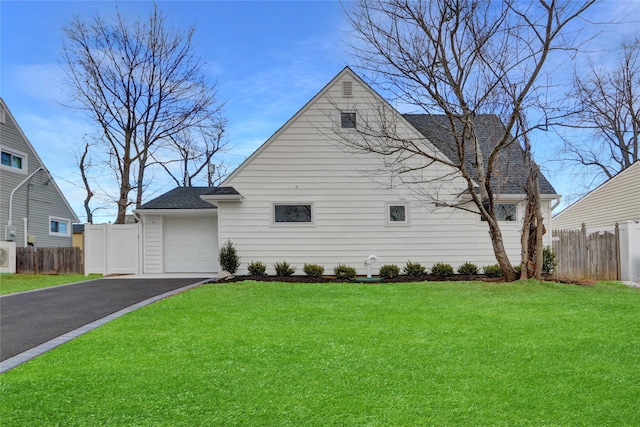 view of front of property with driveway, a shingled roof, a front yard, and fence