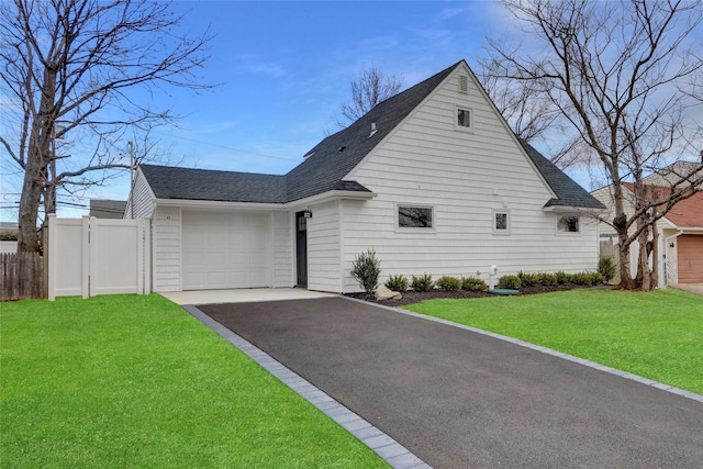 view of front of property with aphalt driveway, a shingled roof, an attached garage, fence, and a front lawn