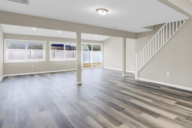 basement with recessed lighting, wood finished floors, baseboards, and stairs