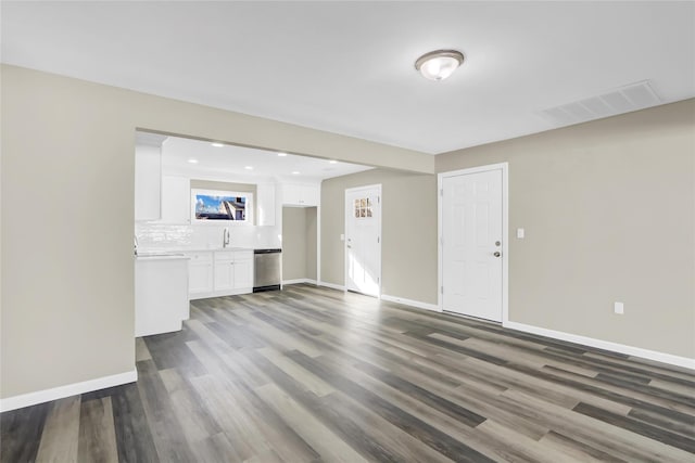 unfurnished living room featuring baseboards, visible vents, wood finished floors, a sink, and recessed lighting