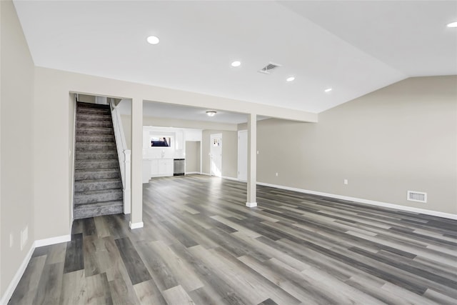 finished below grade area featuring stairs, visible vents, and baseboards