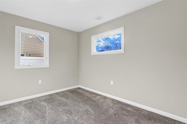 carpeted spare room with baseboards and visible vents