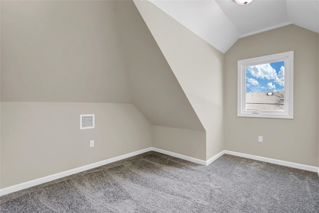 additional living space with vaulted ceiling, carpet, visible vents, and baseboards