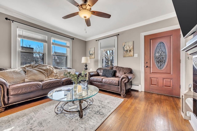 living room with a baseboard heating unit, wood-type flooring, crown molding, and a ceiling fan