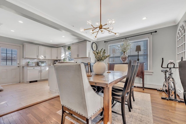 dining area featuring a chandelier, light wood finished floors, ornamental molding, and recessed lighting