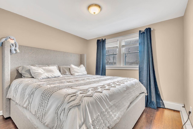 bedroom with baseboards and wood finished floors