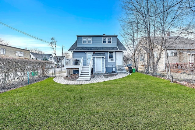 rear view of property featuring a yard, roof with shingles, and a fenced backyard