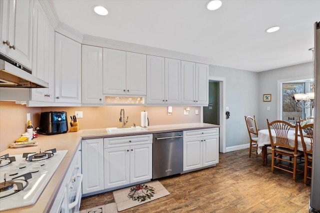 kitchen featuring a sink, white appliances, under cabinet range hood, and white cabinetry