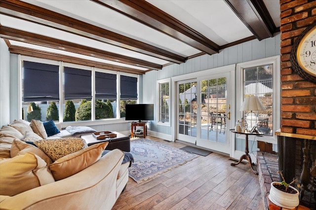 living area featuring beamed ceiling and wood finished floors