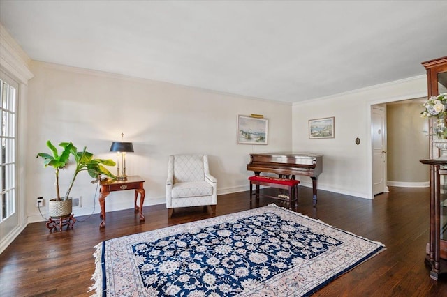 living area with crown molding, wood finished floors, and baseboards