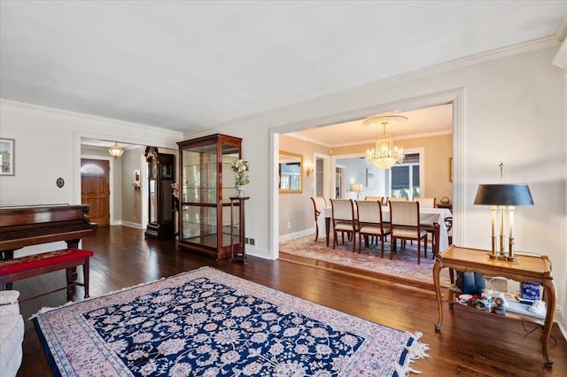 living area with a chandelier, baseboards, and hardwood / wood-style floors