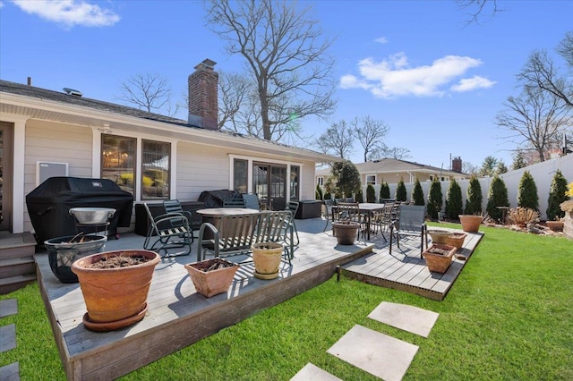 view of patio with fence, an outdoor fire pit, outdoor dining space, a deck, and area for grilling