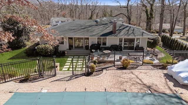 exterior space featuring a chimney, fence private yard, a patio, and a front yard