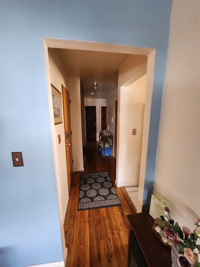 hall featuring baseboards and wood finished floors