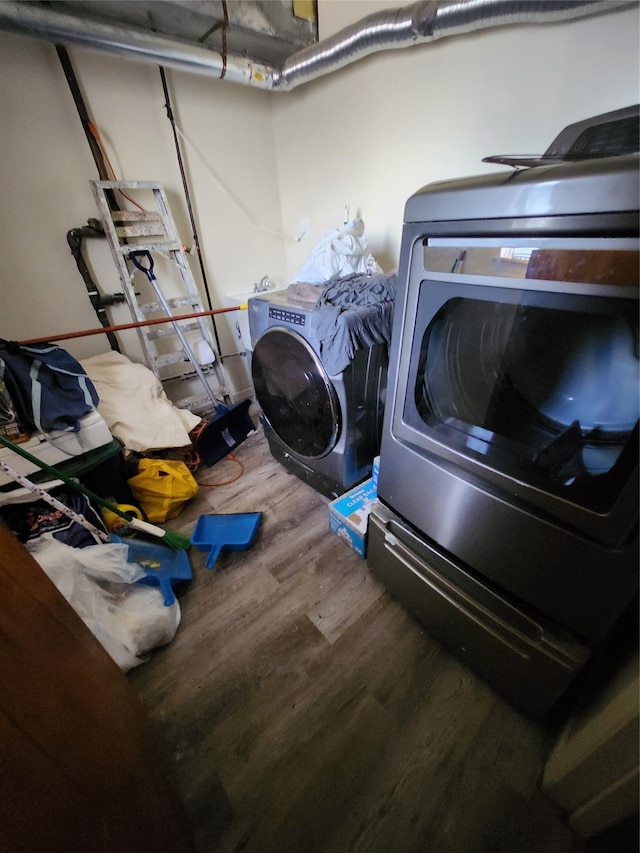 clothes washing area featuring laundry area, wood finished floors, and independent washer and dryer