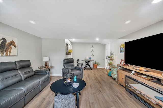 living room featuring recessed lighting, baseboards, and light wood finished floors