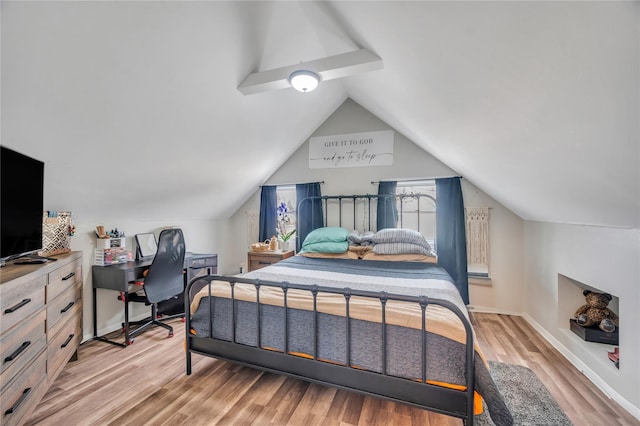 bedroom with light wood-style floors, vaulted ceiling, and baseboards