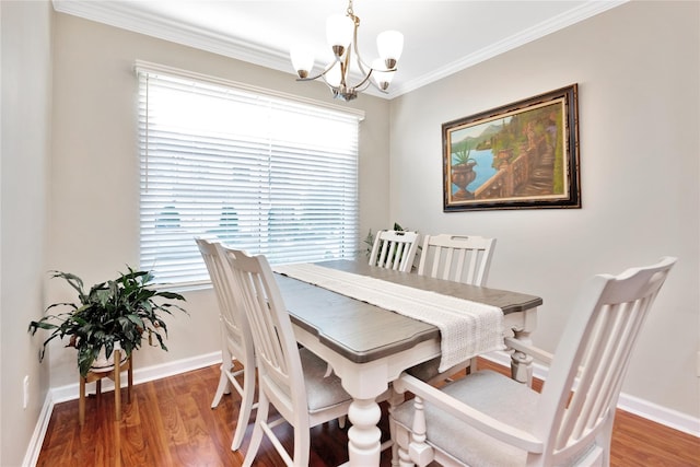 dining area with a notable chandelier, ornamental molding, wood finished floors, and baseboards