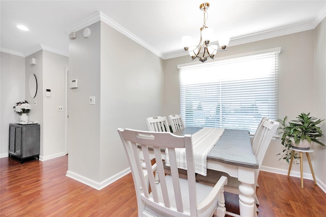 dining room featuring ornamental molding, a chandelier, baseboards, and wood finished floors