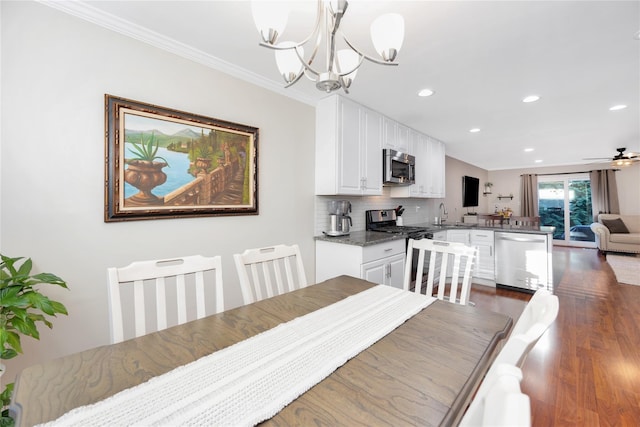 dining space with dark wood-style floors, recessed lighting, crown molding, and ceiling fan with notable chandelier