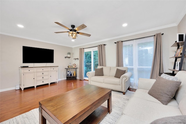 living room featuring ceiling fan, baseboards, crown molding, and wood finished floors