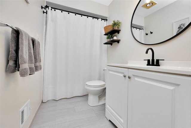 bathroom featuring visible vents, vanity, and toilet