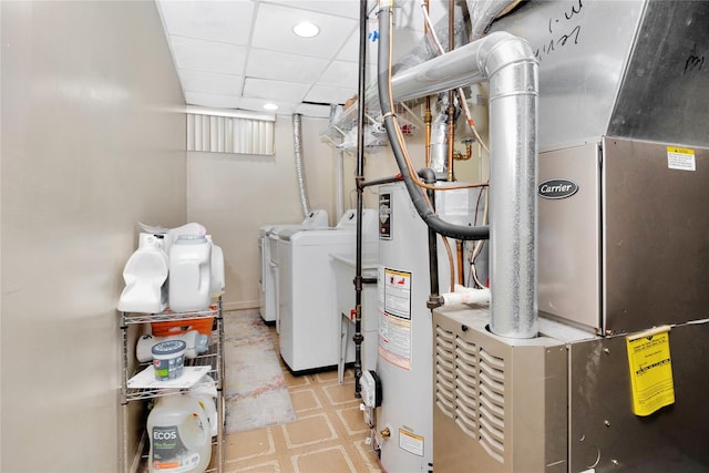 utility room featuring heating unit, gas water heater, and washer and dryer