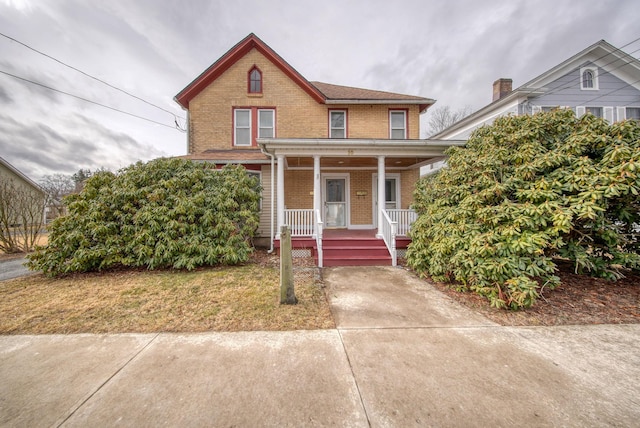 view of front facade with a porch and brick siding