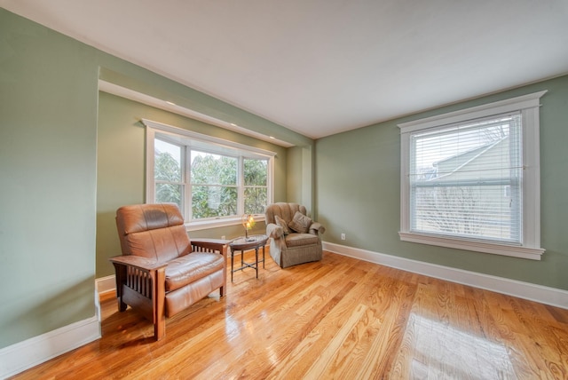 sitting room featuring light wood finished floors, plenty of natural light, and baseboards