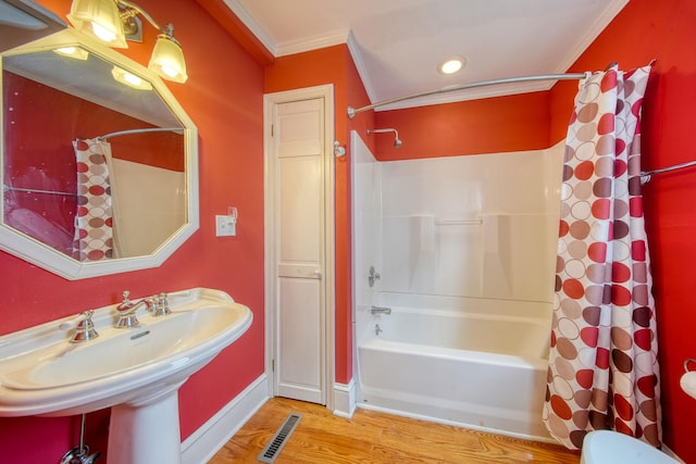 bathroom featuring visible vents, shower / bath combo with shower curtain, crown molding, and wood finished floors