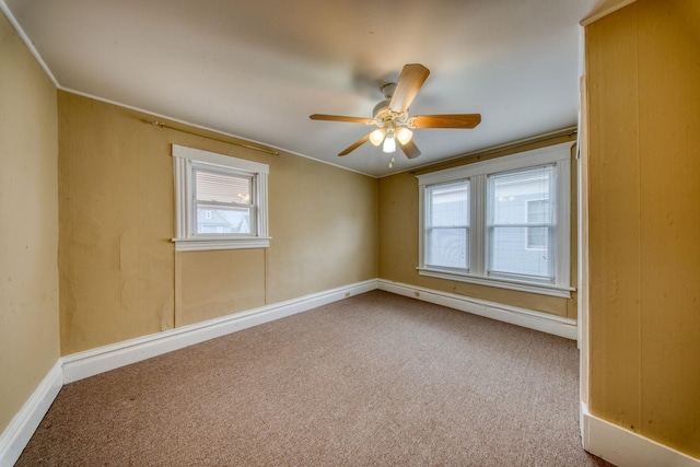 empty room with baseboards, carpet floors, a ceiling fan, and a healthy amount of sunlight